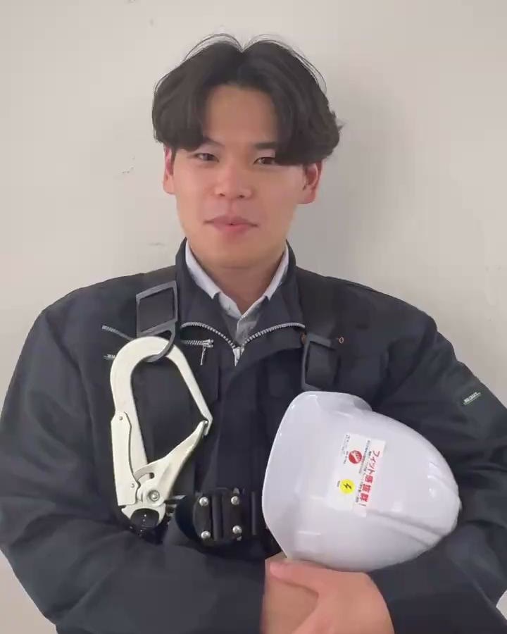 ヘルメットを抱えた作業着の男性